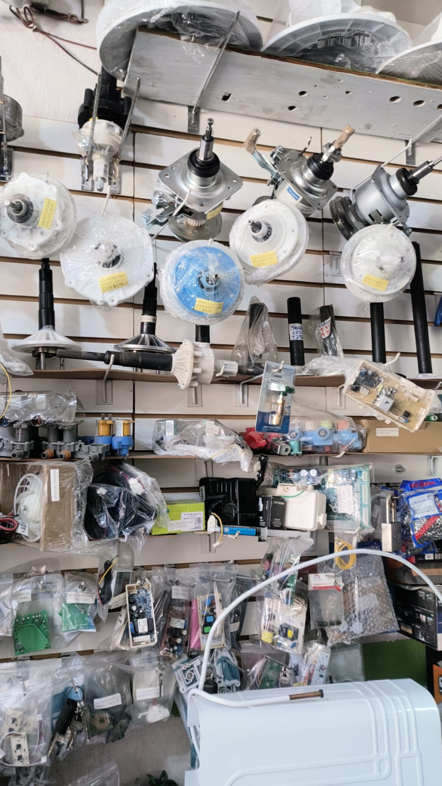 Motores, transmisiones y tarjetas electrónicas para lavadoras exhibidos en la tienda