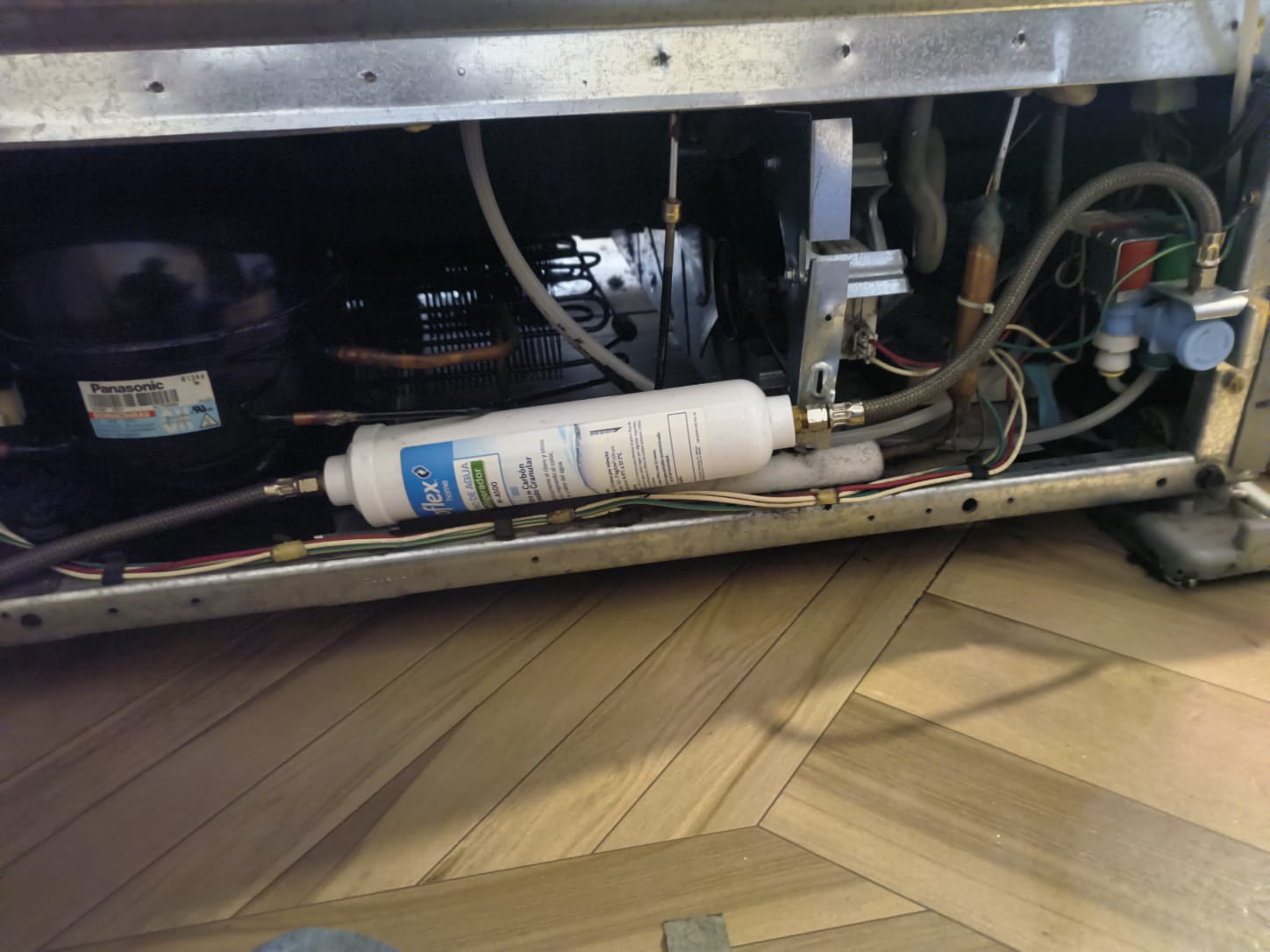 Parte inferior del mismo refrigerador limpia, con condensador despejado y filtro de agua nuevo instalado