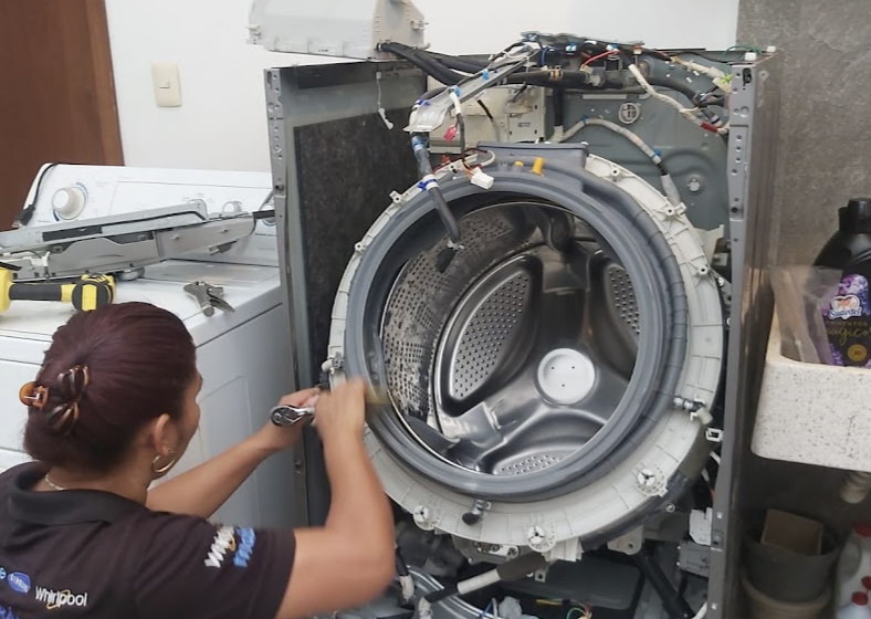 Técnica de SERVI-RAPIDO reparando una lavadora en el taller